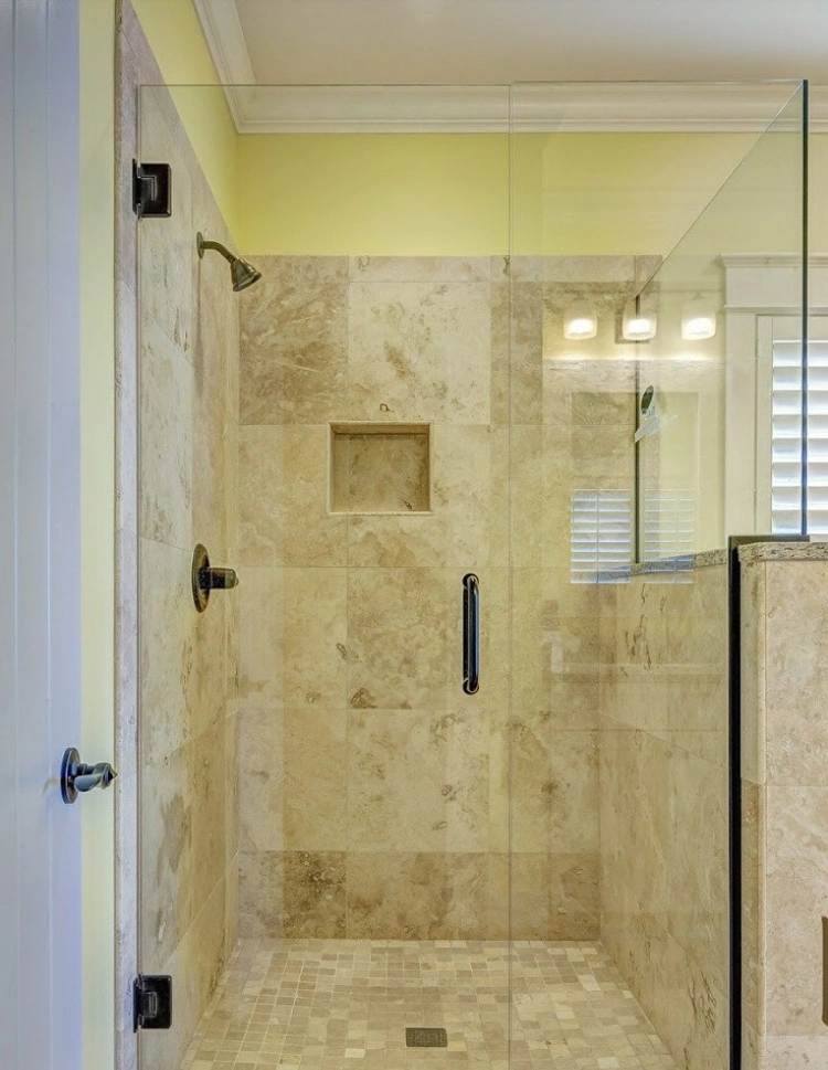 Pose de carrelage en marbre et travertin sur un sol de salle de bain existant sans démolition.