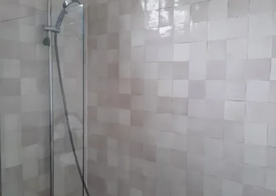 Salle de bain de luxe avec dalles XXL imitation marbre blanc et miroir LED.